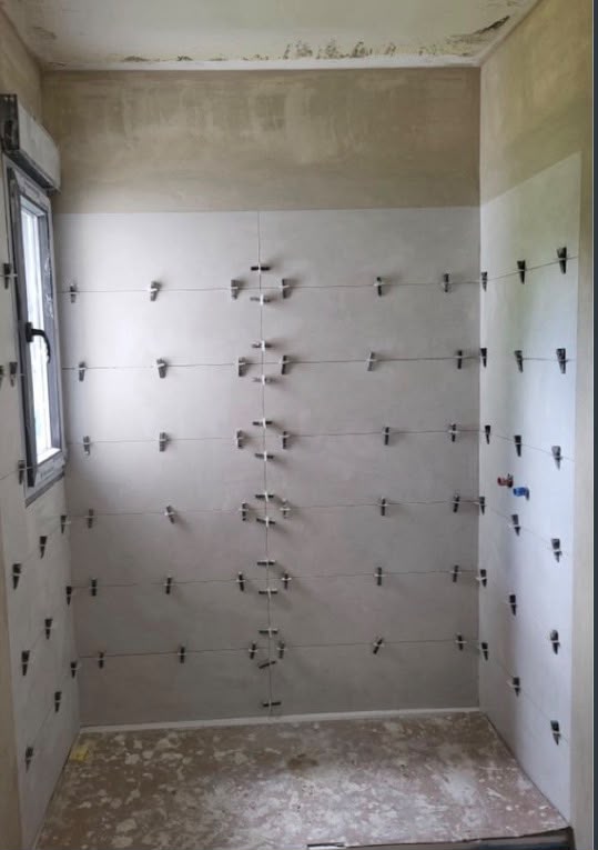 Alicatado de baño en ejecución con niveladores y replanteo de juntas