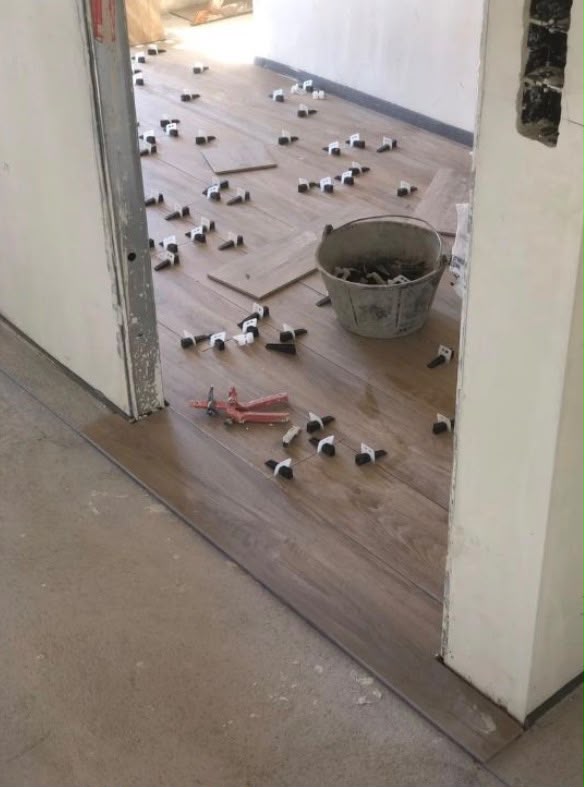 Solado de porcelánico imitación madera en proceso de colocación con sistema de nivelación